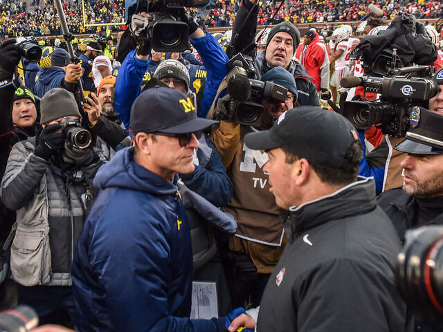 ANN ARBOR, MICHIGAN - NOVEMBER 30: Head Coach Ryan Day (R) of the Ohio State Buckeyes shakes hands with Head Coach Jim Harbaugh (L) of the Michigan Wolverines after a college football game at Michigan Stadium on November 30, 2019 in Ann Arbor, MI. The Ohio State Buckeyes won the game 56-27 over the Michigan Wolverines.