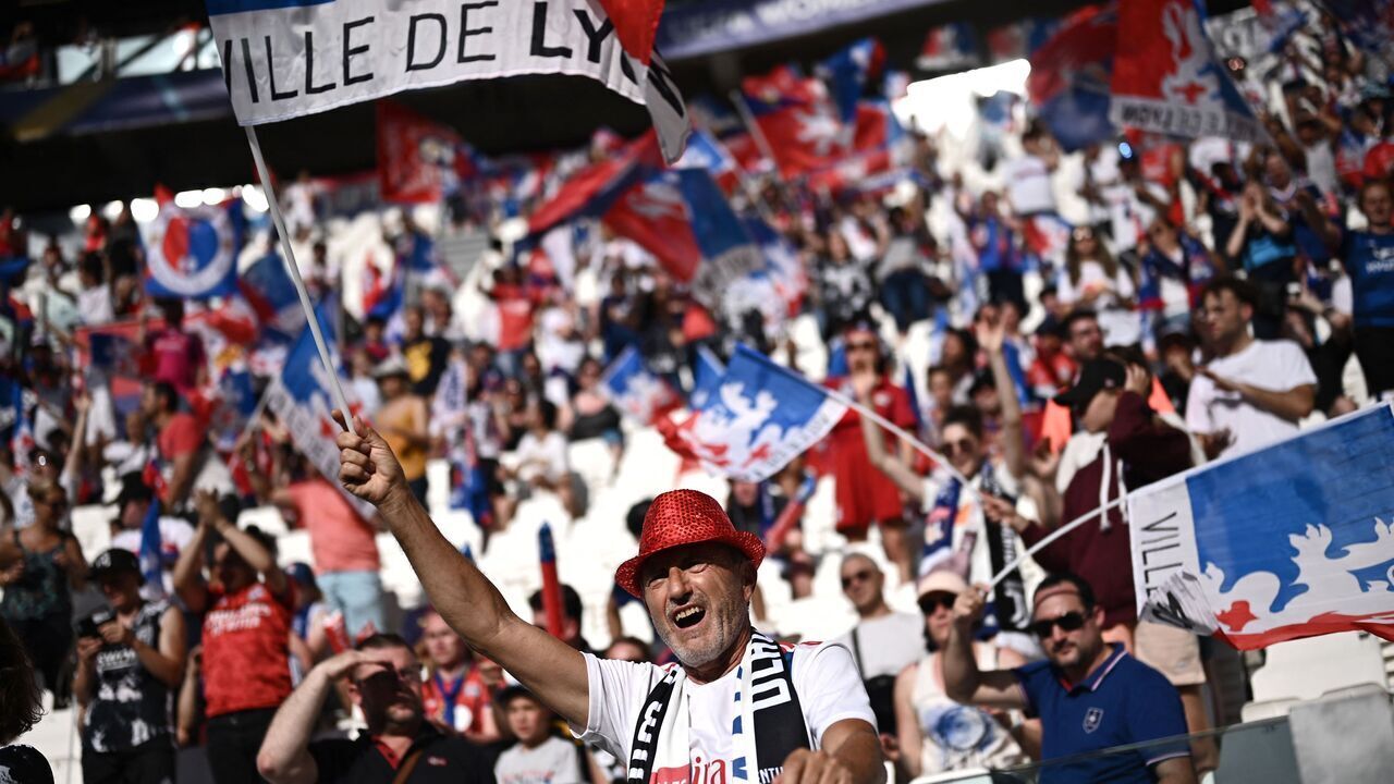 A Lyon fan waves his team's flag while cheering before the UEFA Womens Champions League Final football match between Spain's Barcelona and France's Lyon at the Allianz Stadium in the Italian city of Turin on May 21, 2022.