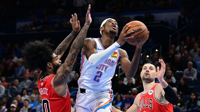 OKLAHOMA CITY, OKLAHOMA - NOVEMBER 22: Shai Gilgeous-Alexander #2 of the Oklahoma City Thunder goes to the basket between Coby White #0 and Nikola Vucevic #9 of the Chicago Bulls during the second half at Paycom Center on November 22, 2023 in Oklahoma City, Oklahoma.