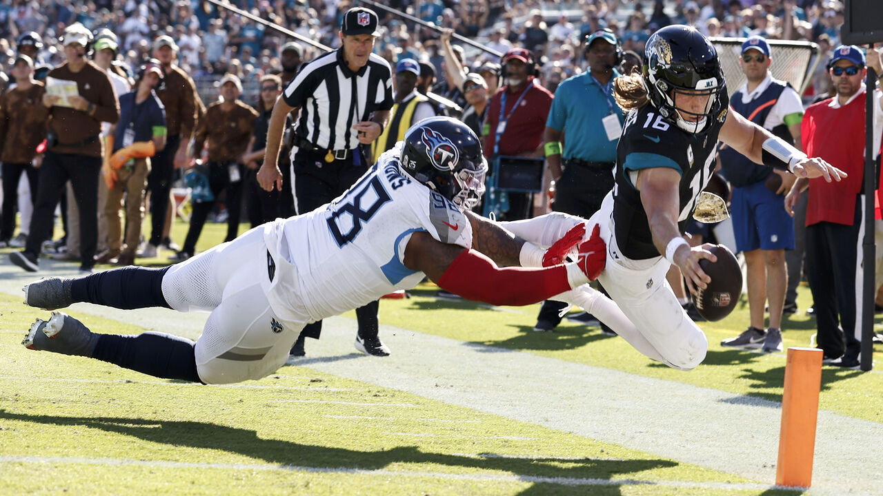 JACKSONVILLE, FL - NOVEMBER 19: Quarterback Trevor Lawrence #16 of the Jacksonville Jaguars dives in for a touchdown over defensive tackle Jeffery Simmons #98 of the Tennessee Titans at EverBank Stadium on November 19, 2023 in Jacksonville, Florida. The Jaguars defeated the Titans 34-14.