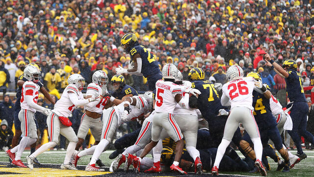 ANN ARBOR, MICHIGAN - NOVEMBER 27: Hassan Haskins #25 of the Michigan Wolverines jumps into the end zone for a touchdown against the Ohio State Buckeyes during the second quarter at Michigan Stadium on November 27, 2021 in Ann Arbor, Michigan.