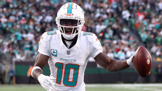 EAST RUTHERFORD, NEW JERSEY - NOVEMBER 24: Tyreek Hill #10 of the Miami Dolphins scores a seven yard touchdown pass against the New York Jets during the second quarter in the game at MetLife Stadium on November 24, 2023 in East Rutherford, New Jersey.
