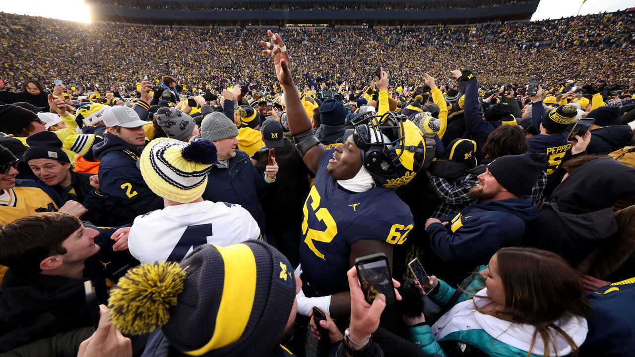 ANN ARBOR, MICHIGAN - NOVEMBER 25: Raheem Anderson #62 of the Michigan Wolverines celebrates with fans on the field after defeating the Ohio State Buckeyes in the game at Michigan Stadium on November 25, 2023 in Ann Arbor, Michigan.