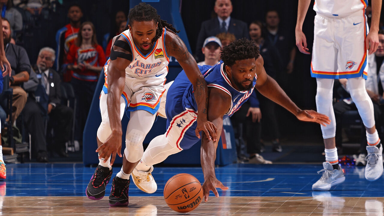OKLAHOMA CITY, OK - NOVEMBER 25: Luguentz Dort #5 of the Oklahoma City Thunder and Joel Embiid #21 of the Philadelphia 76ers dive for the bal on November 25, 2023 at Paycom Arena in Oklahoma City, Oklahoma. Mandatory Copyright Notice: Copyright 2023 NBAE