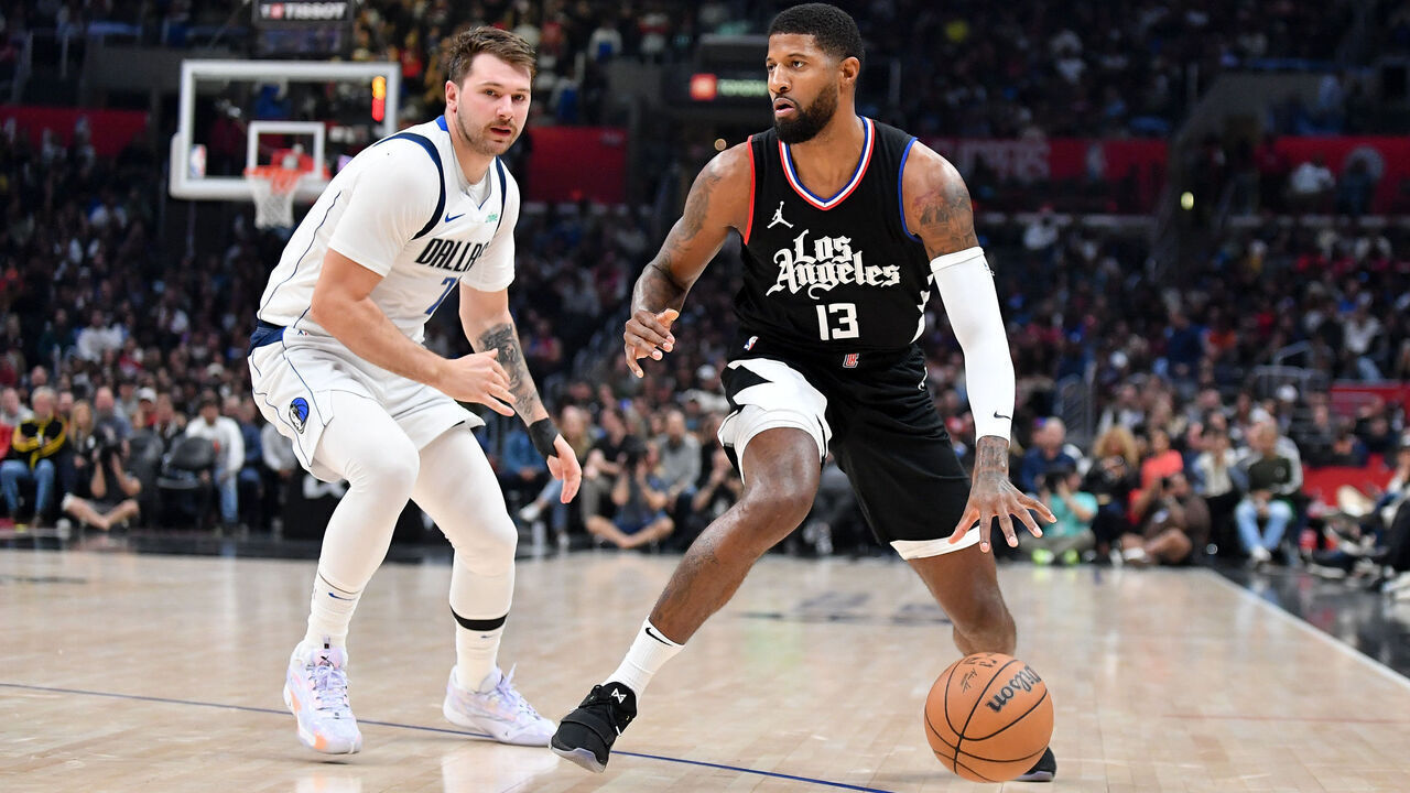 LOS ANGELES, CALIFORNIA - NOVEMBER 25: Paul George #13 of the LA Clippers dribbles the ball against Luka Doncic #77 of the Dallas Mavericks during the first half at Crypto.com Arena on November 25, 2023 in Los Angeles, California.