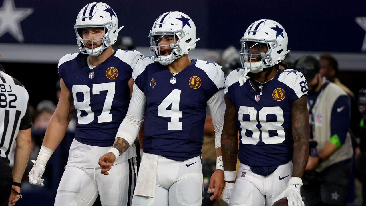 ARLINGTON, TEXAS - NOVEMBER 23: Dak Prescott #4 and CeeDee Lamb #88 of the Dallas Cowboys celebrates after a touchdown with Jake Ferguson #87 in the game against the Washington Commanders during the third quarter at AT&T Stadium on November 23, 2023 in Arlington, Texas.