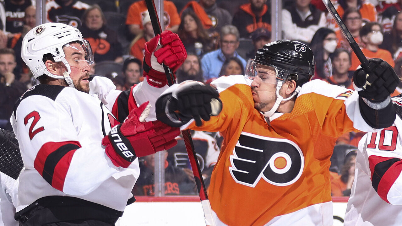 PHILADELPHIA, PENNSYLVANIA - OCTOBER 13: Brendan Smith #2 of the New Jersey Devils (L) and Travis Konecny #11 of the Philadelphia Flyers (C) collide at Wells Fargo Center on October 13, 2022 in Philadelphia, Pennsylvania.