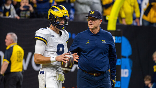 INDIANAPOLIS, INDIANA - DECEMBER 02: J.J. McCarthy #9 (L) and Head Football Coach Jim Harbaugh (R) of the Michigan Wolverines are seen on the field before the Big Ten Championship against the Iowa Hawkeyes at Lucas Oil Stadium on December 02, 2023 in Indianapolis, Indiana.