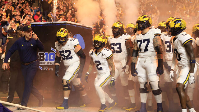 INDIANAPOLIS, INDIANA - DECEMBER 02: Head coach Jim Harbaugh of the Michigan Wolverines leads his team onto the field prior to the game against the Iowa Hawkeyes during the Big Ten Championship at Lucas Oil Stadium on December 02, 2023 in Indianapolis, Indiana.