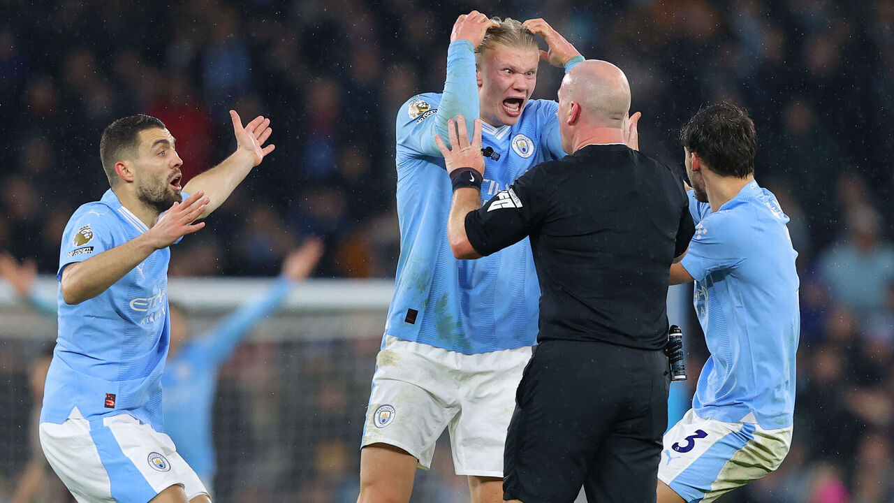 MANCHESTER, ENGLAND - DECEMBER 03: Referee Simon Hooper is surrounded by Erling Haaland, Mateo Kovacic and Ruben Dias of Manchester City after he stopped the game to award Manchester City a free kick and deny Jack Grealish (not pictured) the chance to play on and have a goal scoring chance during the Premier League match between Manchester City and Tottenham Hotspur at Etihad Stadium on December 03, 2023 in Manchester, England.
