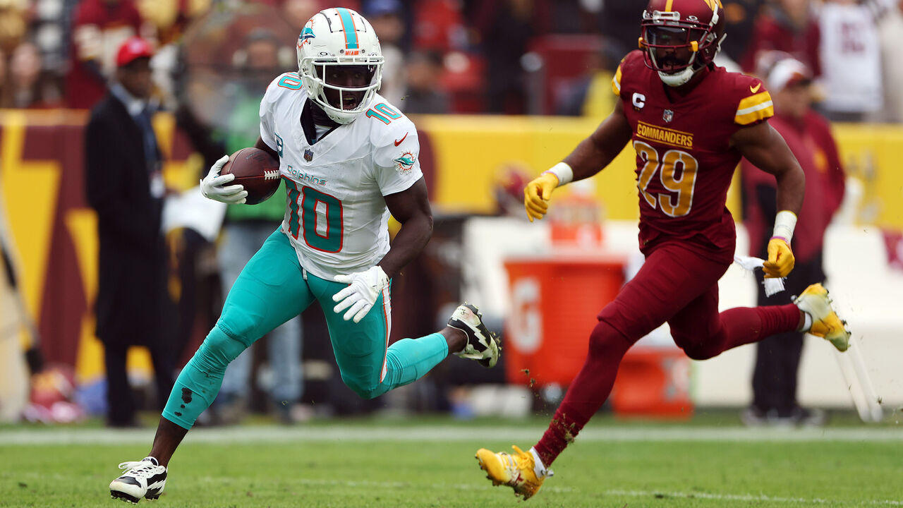 LANDOVER, MARYLAND - DECEMBER 03: Tyreek Hill #10 of the Miami Dolphins carries the ball for a touchdown against the Washington Commanders during the second quarter at FedExField on December 03, 2023 in Landover, Maryland.