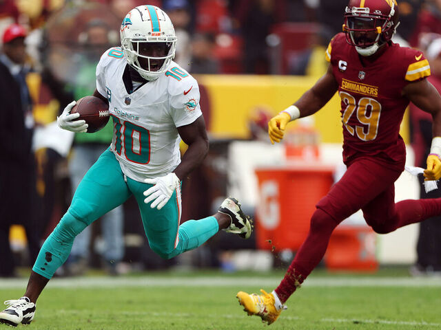 LANDOVER, MARYLAND - DECEMBER 03: Tyreek Hill #10 of the Miami Dolphins carries the ball for a touchdown against the Washington Commanders during the second quarter at FedExField on December 03, 2023 in Landover, Maryland.