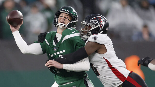 EAST RUTHERFORD, NEW JERSEY - DECEMBER 03: Trevor Siemian #14 of the New York Jets is hit by Lorenzo Carter #0 of the Atlanta Falcons during the fourth quarter at MetLife Stadium on December 03, 2023 in East Rutherford, New Jersey.