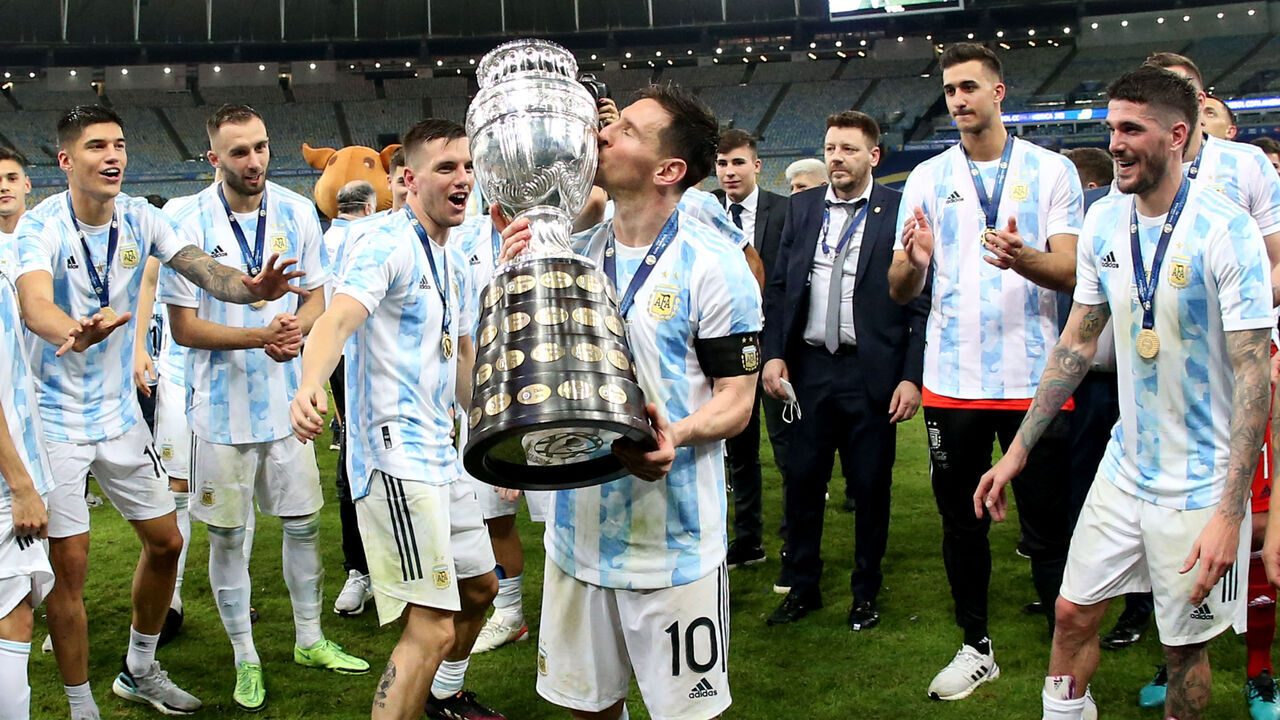 RIO DE JANEIRO, BRAZIL - JULY 10: Lionel Messi of Argentina lift and kiss the Conmebol Copa America Trophy after winning the Final of Copa America Brazil 2021 ,during the Final Match between Brazil and Argentina at Maracana Stadium on July 10, 2021 in Rio de Janeiro, Brazil.
