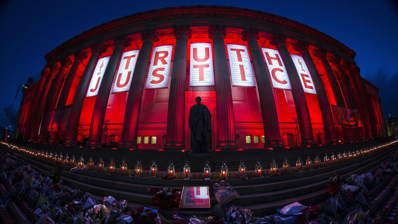 LIVERPOOL, ENGLAND - APRIL 27: A banner reading Truth and Justice is hung from Liverpool's Saint George's Hall and illuminated in red after a vigil for the 96 victims of the Hillsborough tragedy on April 27, 2016 in Liverpool, England. The civic commemoration event marked the outcome of the fresh inquests into the 1989 Hillsborough disaster, in which 96 football supporters were crushed to death, and concluded yesterday with a verdict of unlawful killing. Relatives, Liverpool supporters and members of the public are taking part in the vigil at St George's Hall where a candle is lit for each of the 96 victims who lost their lives during a crush at the Hillsborough football ground in Sheffield, South Yorkshire in 1989.