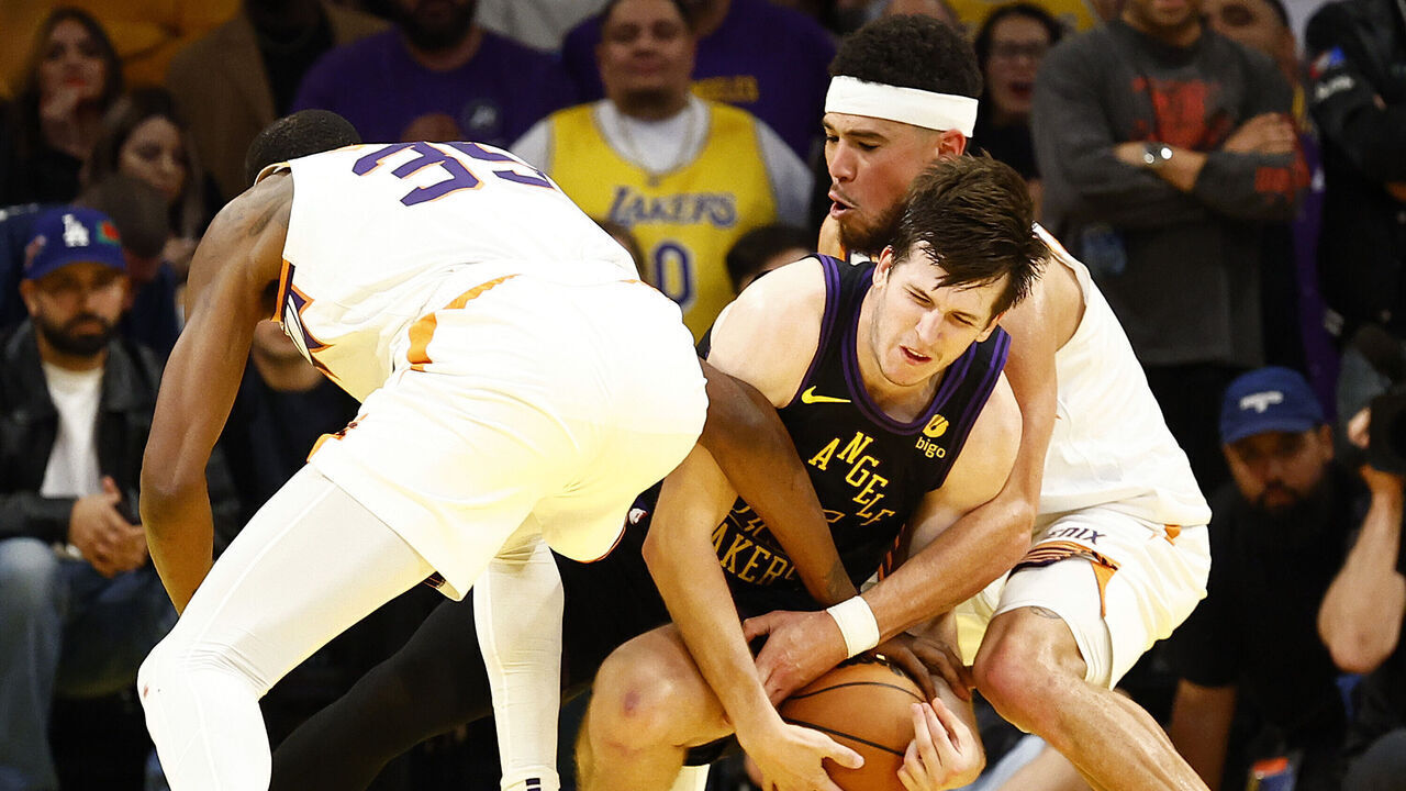 LOS ANGELES, CALIFORNIA - DECEMBER 05: Austin Reaves #15 of the Los Angeles Lakers is defended by Kevin Durant #35 and Devin Booker #1 of the Phoenix Suns in the second half during the 2023 NBA In-Season Tournament quarterfinals at Crypto.com Arena on December 05, 2023 in Los Angeles, California. NOTE TO USER: User expressly acknowledges and agrees that, by downloading and/or using this photograph, user is consenting to the terms and conditions of the Getty Images License Agreement.