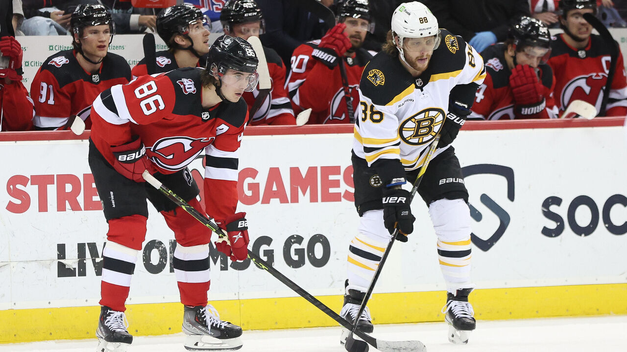 NEWARK, NJ - DECEMBER 28: New Jersey Devils center Jack Hughes (86) and Boston Bruins right wing David Pastrnak (88) await a face-off during the National Hockey League game between the Boston Bruins and the New Jersey Devils on December 28, 2022 at Prudential Center in Newark, NJ.