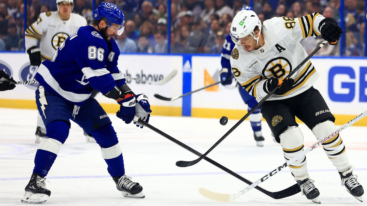 TAMPA, FLORIDA - NOVEMBER 20: David Pastrnak #88 of the Boston Bruins and Nikita Kucherov #86 of the Tampa Bay Lightning fight for the puck in the first period during a game at Amalie Arena on November 20, 2023 in Tampa, Florida.
