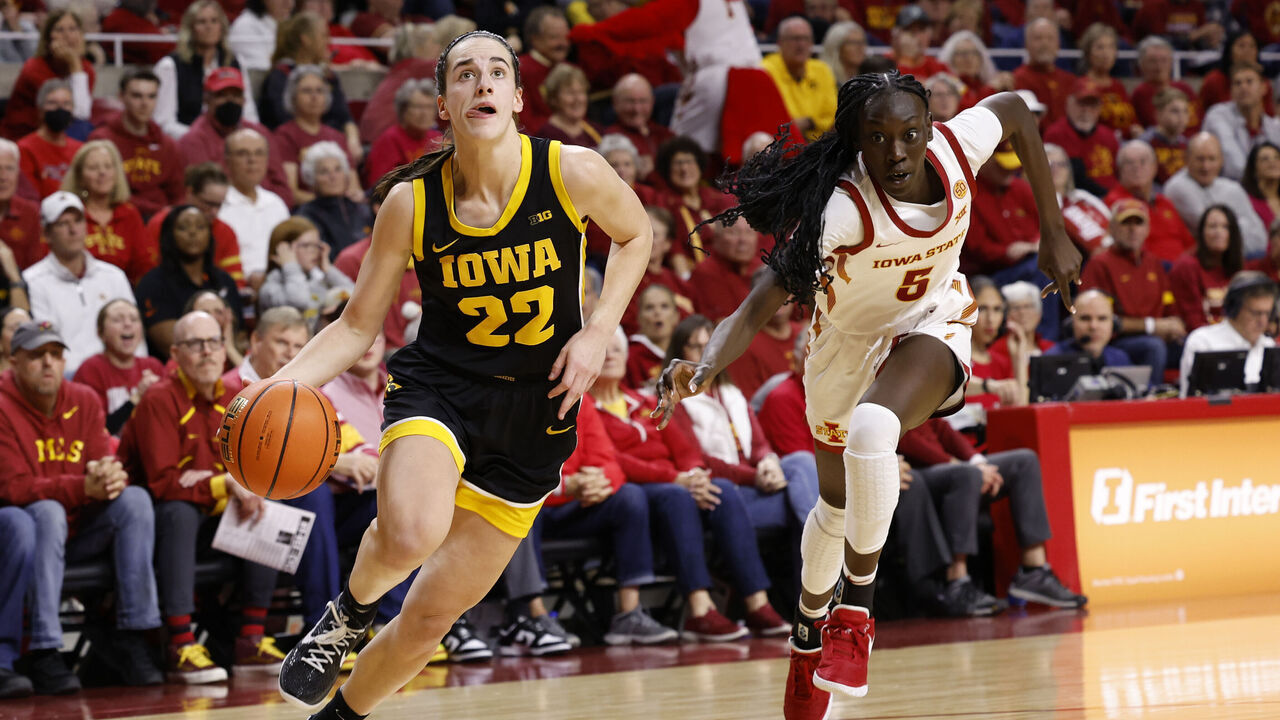 AMES, IA - DECEMBER 6: Caitlin Clark #22 of the Iowa Hawkeyes drives by Nyamer Diew #5 of the Iowa State Cyclones in the first half at Hilton Coliseum on December 6, 2023 in Ames, Iowa.