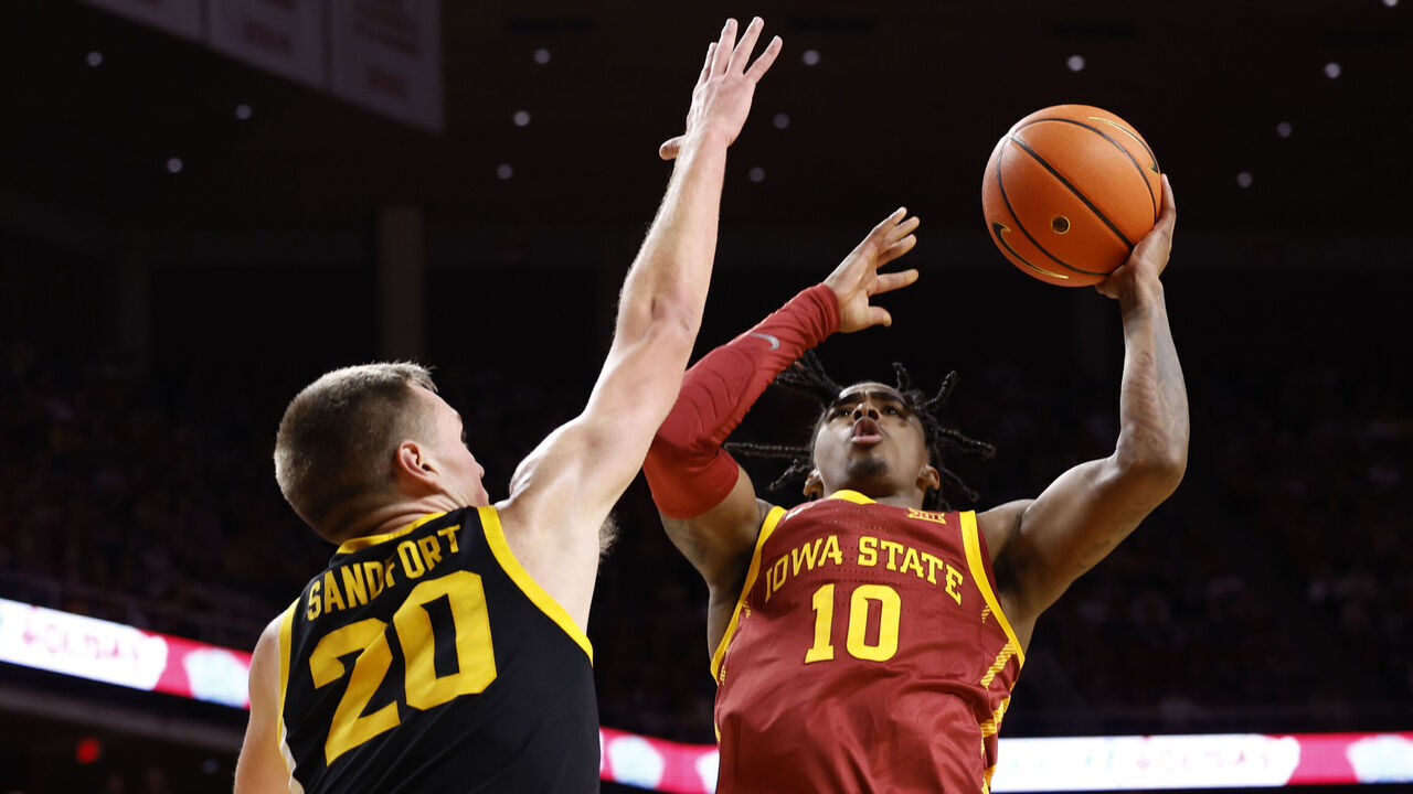 AMES, IA - DECEMBER 7: Keshon Gilbert #10 of the Iowa State Cyclones takes a shot as Payton Sandfort #20 of the Iowa Hawkeyes blocks in the first half of play at Hilton Coliseum on December 7, 2023 in Ames, Iowa.