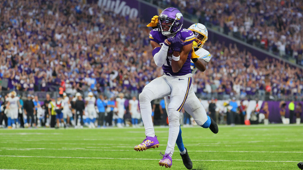 MINNEAPOLIS, MINNESOTA - SEPTEMBER 24: Justin Jefferson #18 of the Minnesota Vikings scores a touchdown while Asante Samuel Jr. #26 of the Los Angeles Chargers attempts the tackle at U.S. Bank Stadium on September 24, 2023 in Minneapolis, Minnesota.The Los Angeles Chargers defeated the Minnesota Vikings 28-24.
