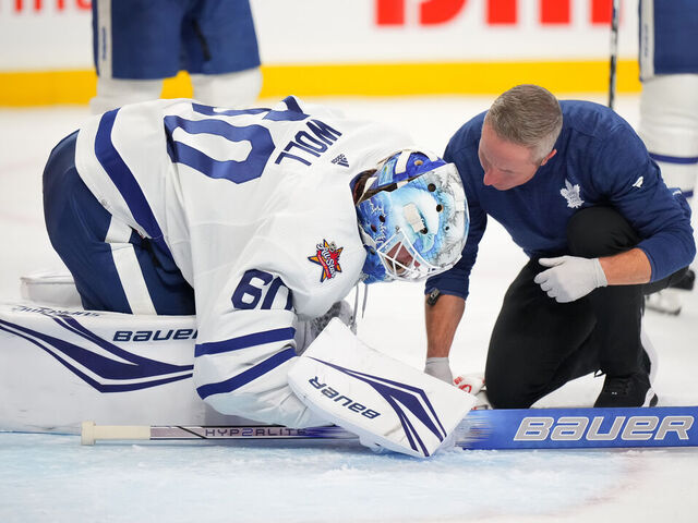 OTTAWA, CANADA - DECEMBER 7: Joseph Woll #60 of the Toronto Maple Leafs speaks to an athletic trainer during a stoppage in play after sustaining an injury against the Ottawa Senators during the third period at Canadian Tire Centre on December 7, 2023 in Ottawa, Ontario, Canada.