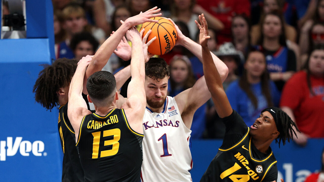 LAWRENCE, KANSAS - DECEMBER 09: Hunter Dickinson #1 of the Kansas Jayhawks controls the ball as Jesus Carralero #13 and Anthony Robinson II #14 of the Missouri Tigers defend during the 2nd half of the game at Allen Fieldhouse on December 09, 2023 in Lawrence, Kansas.