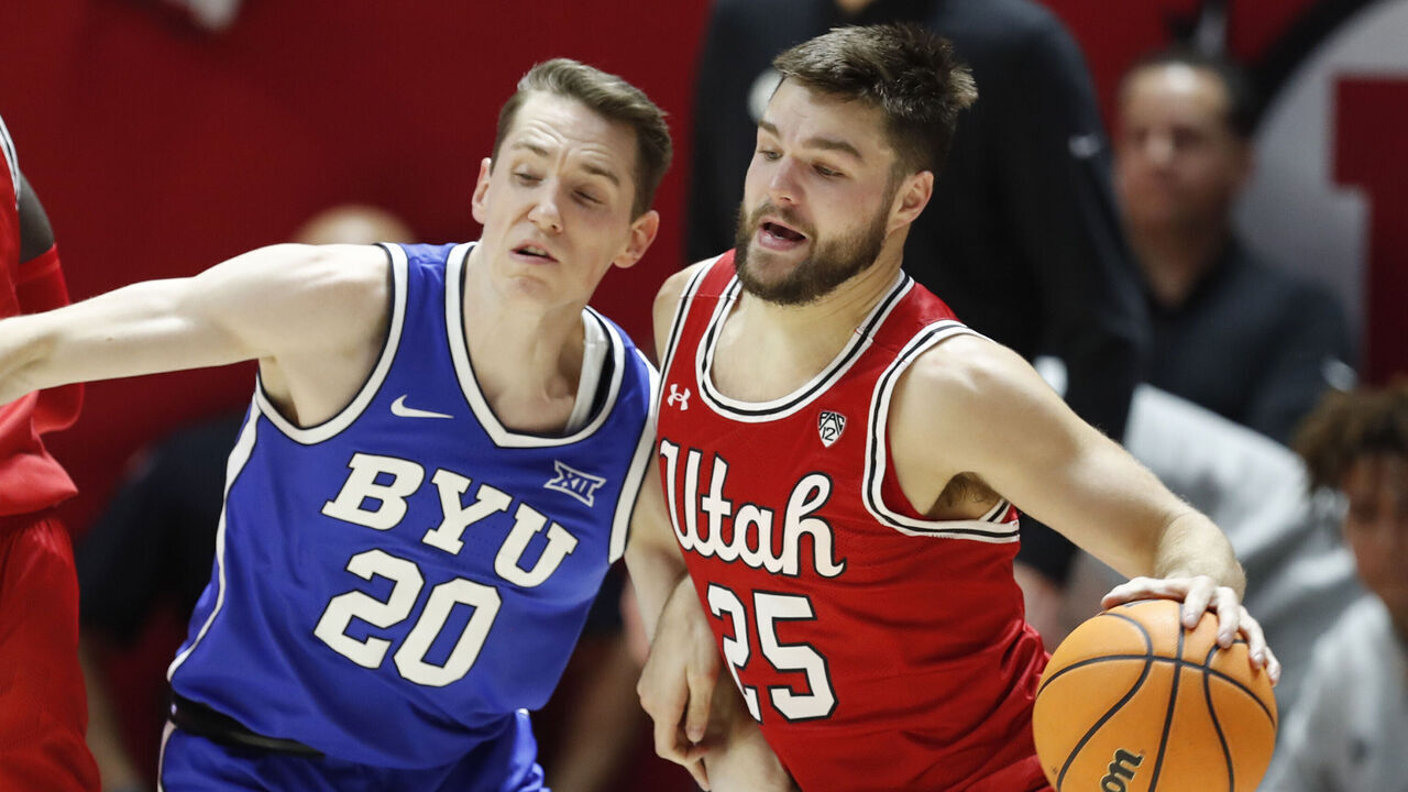 SALT LAKE CITY, UT - DECEMBER 9: Rollie Worster #25 of the Utah Utes drives around Spencer Johnson #20 of the Brigham Young Cougars during the first half of their game at the Jon M Huntsman Center on December 9, 2023 in Salt Lake City, Utah.