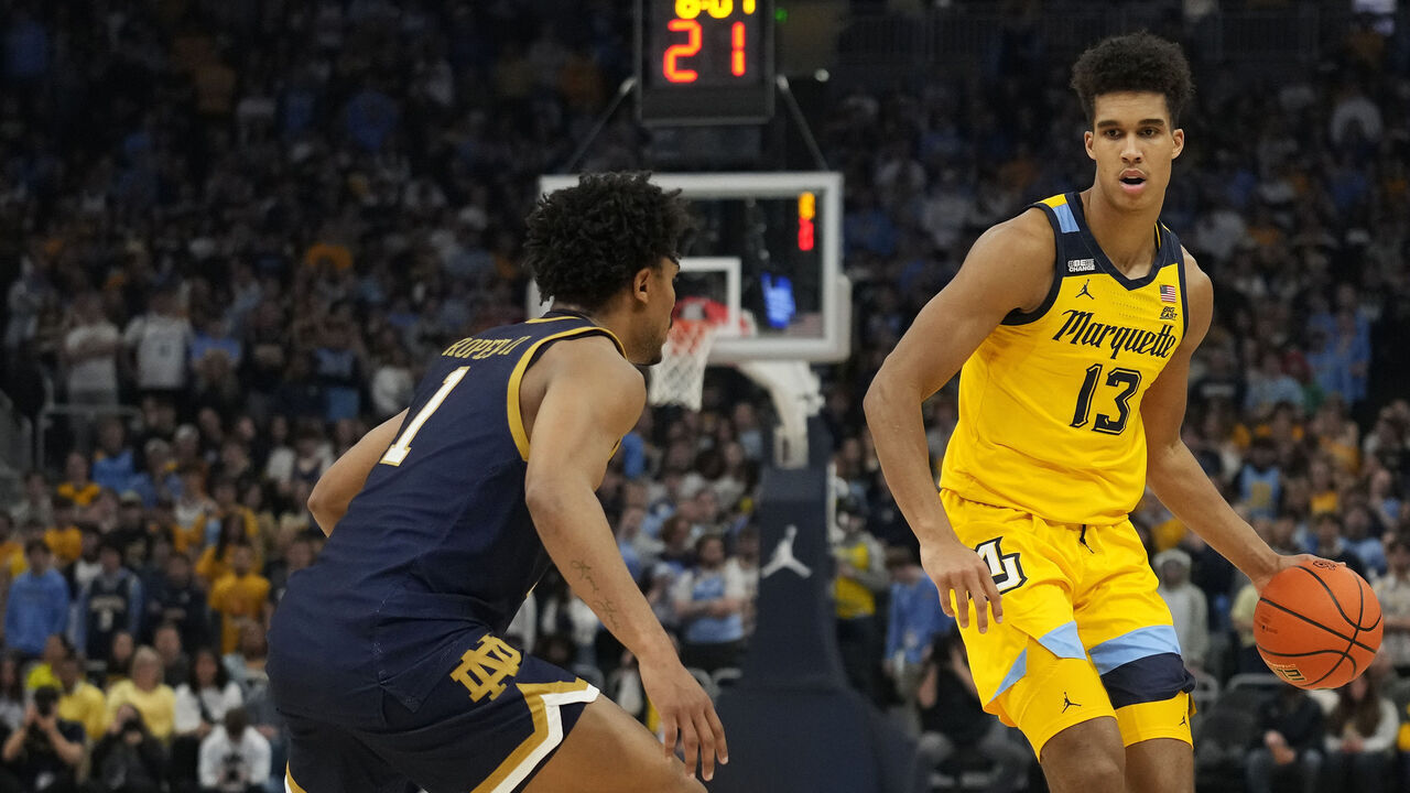 MILWAUKEE, WISCONSIN - DECEMBER 09: Oso Ighodaro #13 of the Marquette Golden Eagles dribbles the ball against Julian Roper II #1 of the Notre Dame Fighting Irish during the first half at Fiserv Forum on December 09, 2023 in Milwaukee, Wisconsin.