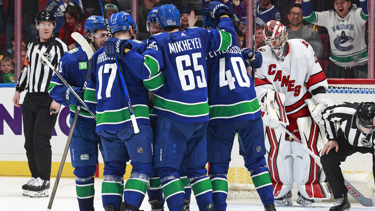 VANCOUVER, CANADA - DECEMBER 09: Elias Pettersson #40 of the Vancouver Canucks is congratulated by teammates after scoring during their NHL game against the Carolina Hurricanes at Rogers Arena on December 9, 2023 in Vancouver, British Columbia, Canada.