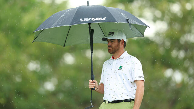 MALELANE, SOUTH AFRICA - DECEMBER 10: Louis Oosthuizen of South Africa looks on while holding an umbrella from the 2nd green as rain falls on Day Four of the Alfred Dunhill Championship at Leopard Creek Country Club on December 10, 2023 in Malelane, South Africa.