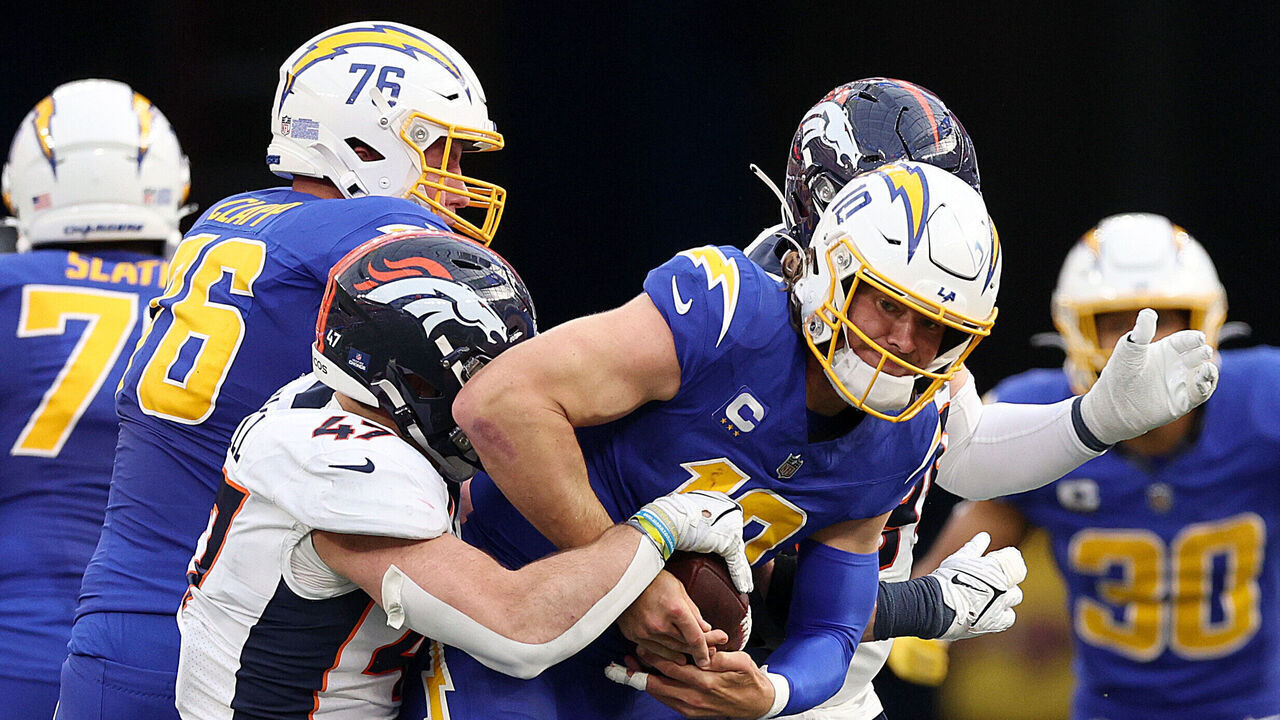 INGLEWOOD, CALIFORNIA - DECEMBER 10: Justin Herbert #10 of the Los Angeles Chargers is sacked by Josey Jewell #47 of the Denver Broncos during the second quarter at SoFi Stadium on December 10, 2023 in Inglewood, California.