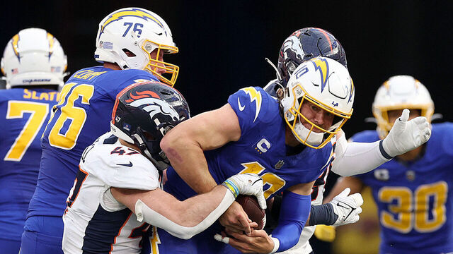 INGLEWOOD, CALIFORNIA - DECEMBER 10: Justin Herbert #10 of the Los Angeles Chargers is sacked by Josey Jewell #47 of the Denver Broncos during the second quarter at SoFi Stadium on December 10, 2023 in Inglewood, California.
