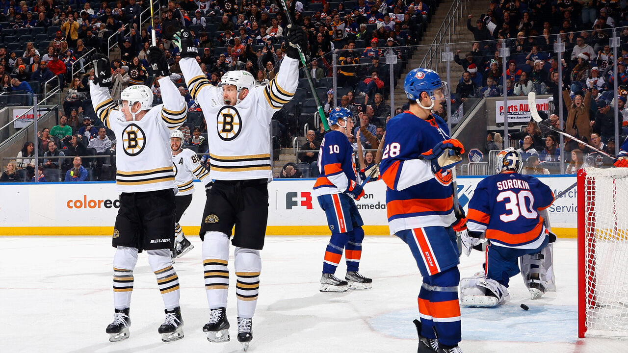ELMONT, NEW YORK - DECEMBER 15: James van Riemsdyk #21 of the Boston Bruins (R) celebrates his third period goal against the New York Islanders and is joined by Morgan Geekie #39 at UBS Arena on December 15, 2023 in Elmont, New York.