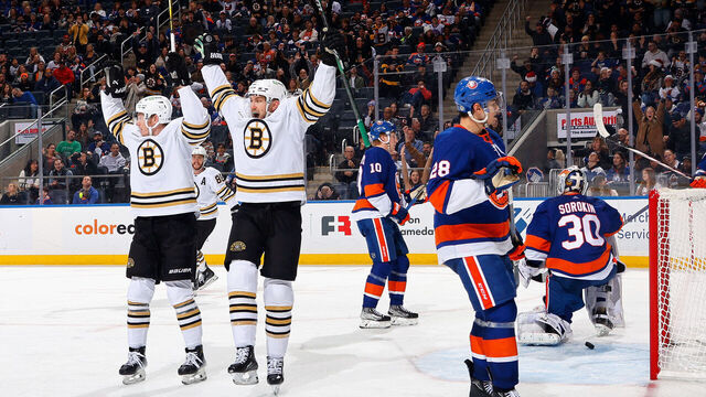 ELMONT, NEW YORK - DECEMBER 15: James van Riemsdyk #21 of the Boston Bruins (R) celebrates his third period goal against the New York Islanders and is joined by Morgan Geekie #39 at UBS Arena on December 15, 2023 in Elmont, New York.
