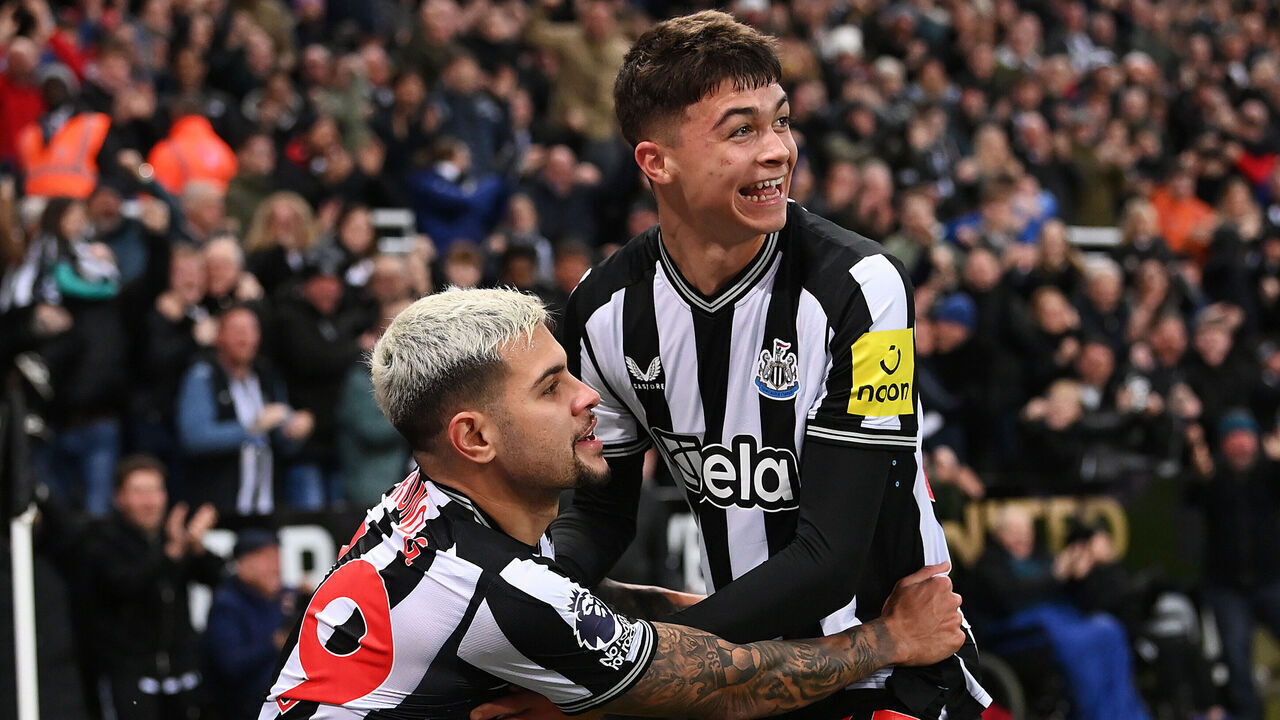 NEWCASTLE UPON TYNE, ENGLAND - DECEMBER 16: Lewis Miley of Newcastle United (R) celebrates with teammate Bruno Guimaraes after scoring their team's first goal during the Premier League match between Newcastle United and Fulham FC at St. James Park on December 16, 2023 in Newcastle upon Tyne, England.