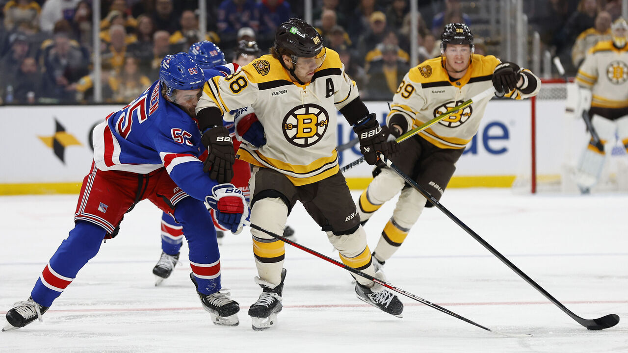 BOSTON, MA - DECEMBER 16: David Pastrnak #88 of the Boston Bruins tries to hold off Ryan Lindgren #55 of the New York Rangers during the first period at TD Garden on December 16, 2023 in Boston, Massachusetts.