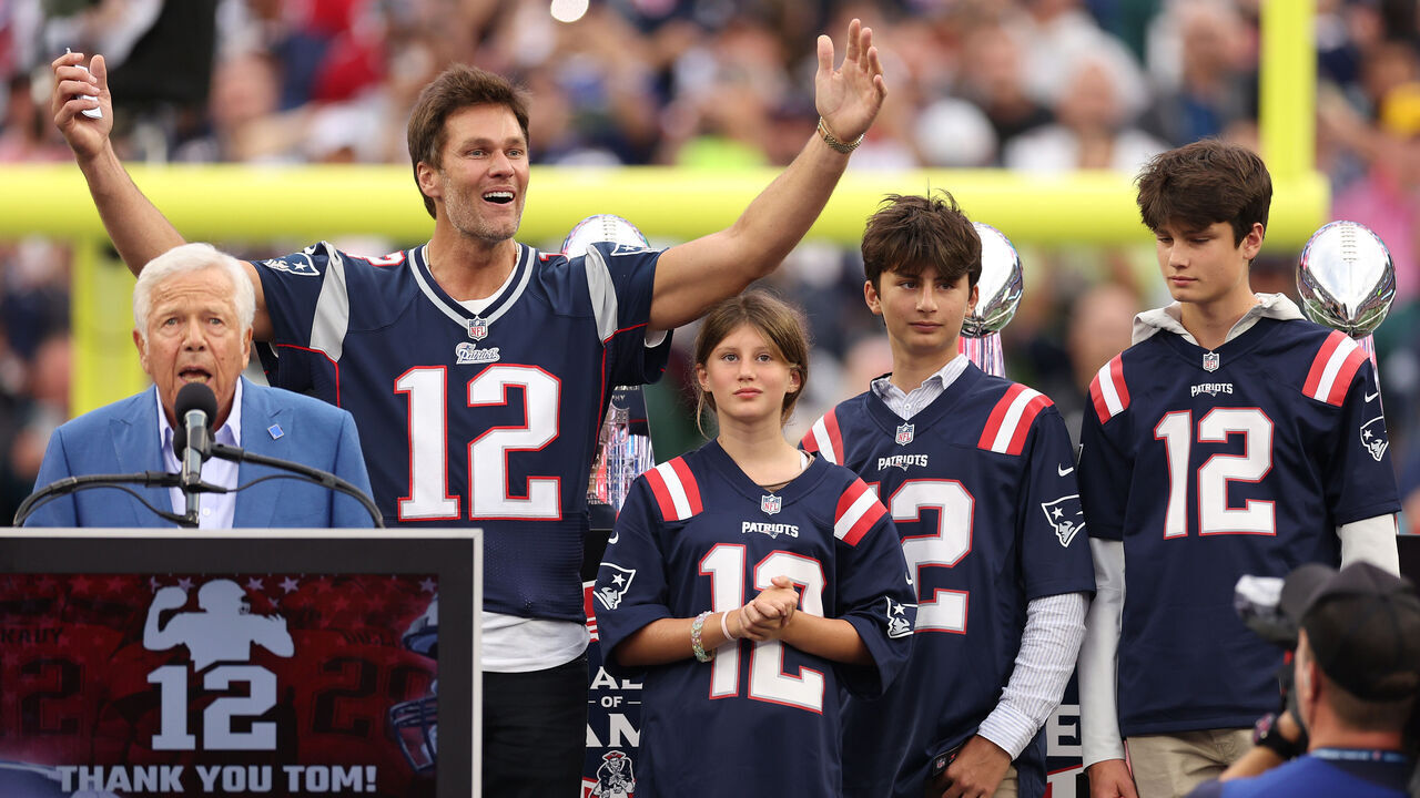 FOXBOROUGH, MASSACHUSETTS - SEPTEMBER 10: New England Patriots owner Robert Kraft speaks while former New England Patriots quarterback Tom Brady reacts while Brady's children, Vivian, Benjamin, and Jack, look on during a ceremony honoring Brady at halftime of New England's game against the Philadelphia Eagles at Gillette Stadium on September 10, 2023 in Foxborough, Massachusetts.