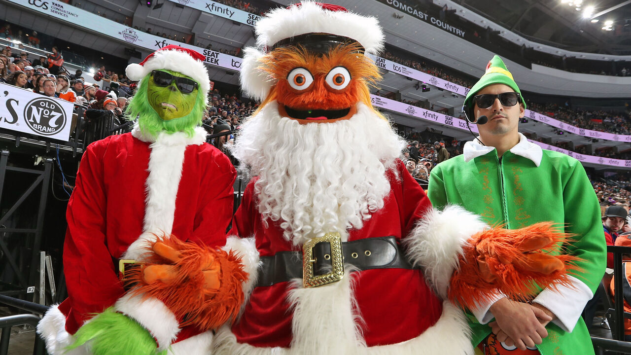 PHILADELPHIA, PENNSYLVANIA - DECEMBER 17: Gritty the mascot of the Philadelphia Flyers dressed as Santa Clause with the Holiday Body Guards pose for a photo during an NHL game against the New York Rangers at the Wells Fargo Center on December 17, 2022 in Philadelphia, Pennsylvania.