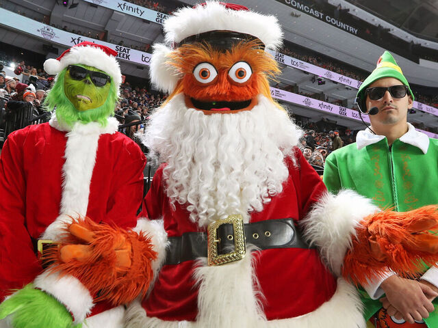 PHILADELPHIA, PENNSYLVANIA - DECEMBER 17: Gritty the mascot of the Philadelphia Flyers dressed as Santa Clause with the Holiday Body Guards pose for a photo during an NHL game against the New York Rangers at the Wells Fargo Center on December 17, 2022 in Philadelphia, Pennsylvania.