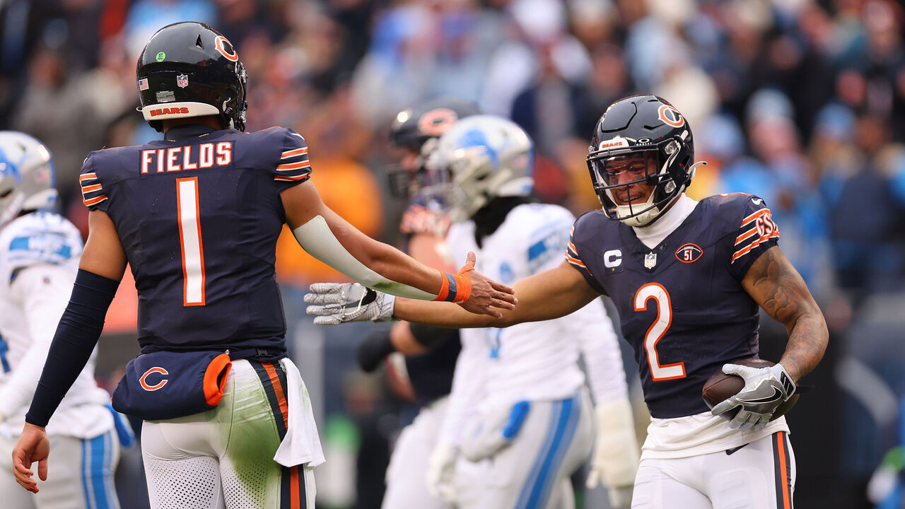CHICAGO, ILLINOIS - DECEMBER 10: DJ Moore #2 of the Chicago Bears high fives Justin Fields #1 after scoring a rushing touchdown against the Detroit Lions during the first quarter at Soldier Field on December 10, 2023 in Chicago, Illinois.