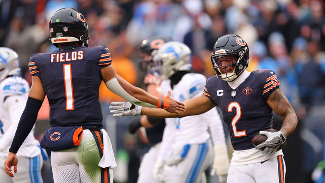 CHICAGO, ILLINOIS - DECEMBER 10: DJ Moore #2 of the Chicago Bears high fives Justin Fields #1 after scoring a rushing touchdown against the Detroit Lions during the first quarter at Soldier Field on December 10, 2023 in Chicago, Illinois.