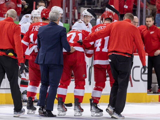 DETROIT, MI - DECEMBER 09: Dylan Larkin #71 of the Detroit Red Wings is helped off the ice by the team medical staff after being injured during the first period of the game against the Ottawa Senators at Little Caesars Arena on December 9, 2023 in Detroit, Michigan.