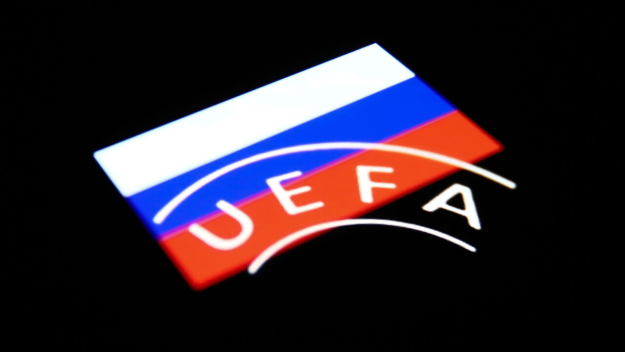 UEFA logo displayed on a phone screen and Russian flag displayed on a phone screen are seen in this multiple exposure illustration photo taken in Krakow, Poland on February 28, 2022. (Photo illustration by Jakub Porzycki/NurPhoto via Getty Images)