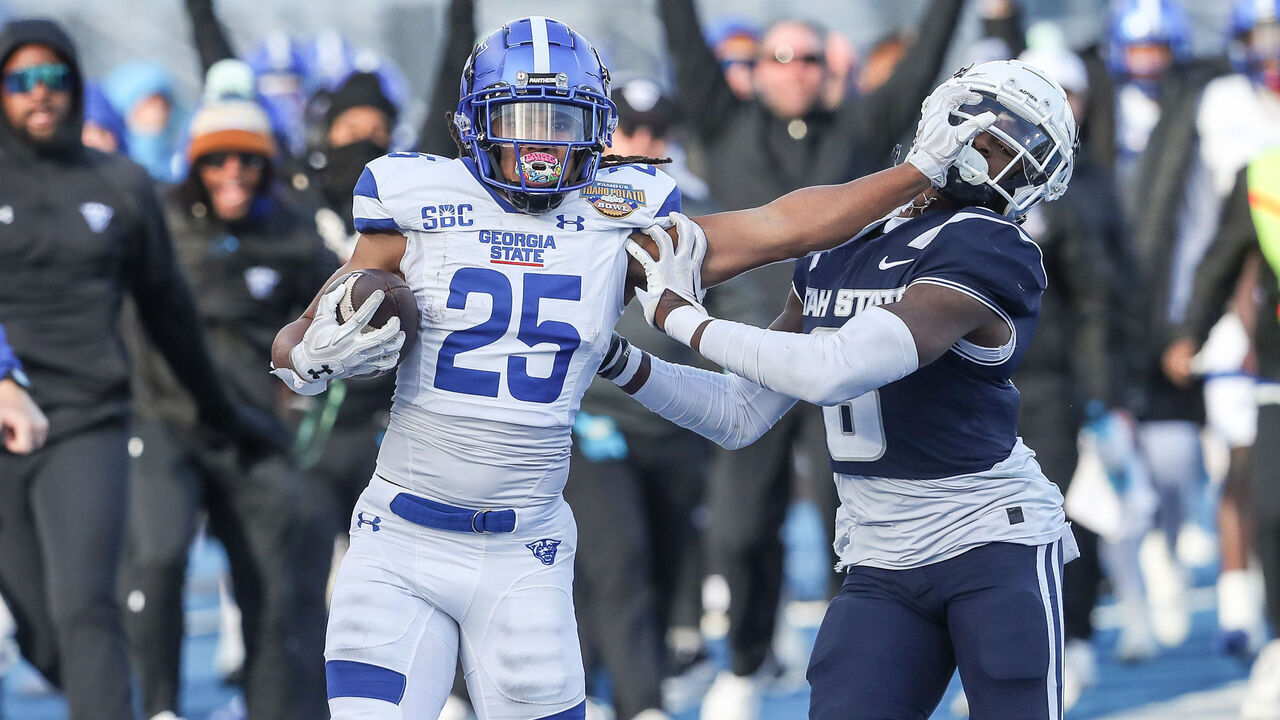 BOISE, ID - DECEMBER 23: Running back Freddie Brock #25 of the Georgia State Panthers stiff-arms safety Ike Larsen #6 of the Utah State Aggies during the first half of the Famous Idaho Potato Bowl at Albertsons Stadium on December 23, 2023 in Boise, Idaho.