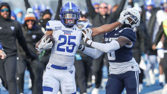 BOISE, ID - DECEMBER 23: Running back Freddie Brock #25 of the Georgia State Panthers stiff-arms safety Ike Larsen #6 of the Utah State Aggies during the first half of the Famous Idaho Potato Bowl at Albertsons Stadium on December 23, 2023 in Boise, Idaho.