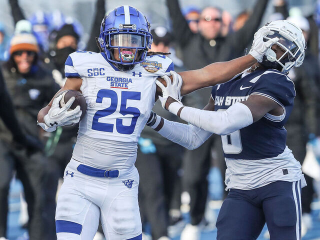 BOISE, ID - DECEMBER 23: Running back Freddie Brock #25 of the Georgia State Panthers stiff-arms safety Ike Larsen #6 of the Utah State Aggies during the first half of the Famous Idaho Potato Bowl at Albertsons Stadium on December 23, 2023 in Boise, Idaho.