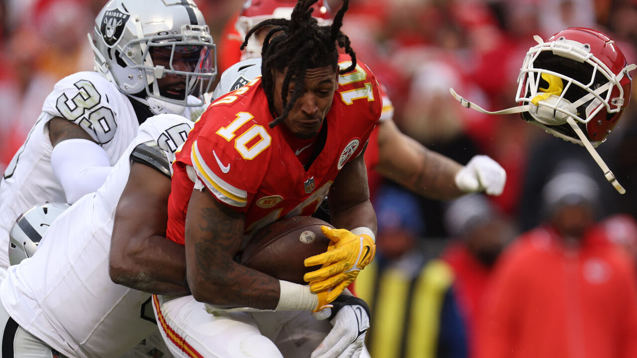 KANSAS CITY, MISSOURI - DECEMBER 25: Isiah Pacheco #10 of the Kansas City Chiefs loses his helmet as he's tackled by Divine Deablo #5 of the Las Vegas Raiders during the third quarter at GEHA Field at Arrowhead Stadium on December 25, 2023 in Kansas City, Missouri.