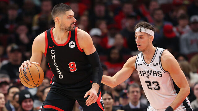 CHICAGO, ILLINOIS - DECEMBER 21: Nikola Vucevic #9 of the Chicago Bulls is defended by Zach Collins #23 of the San Antonio Spurs during the first half at the United Center on December 21, 2023 in Chicago, Illinois.