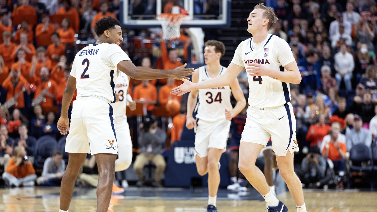 CHARLOTTESVILLE, VIRGINIA - DECEMBER 27: Reece Beekman #2 and Andrew Rohde #4 of the Virginia Cavaliers high five in the first half during a game against the Morgan State Bears at John Paul Jones Arena on December 27, 2023 in Charlottesville, Virginia.